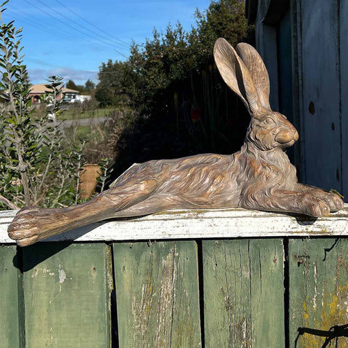 Hares sitting or lying statues grey or earth